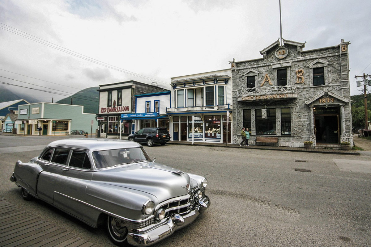 Street view of downtown Skagway stores and an antique car.