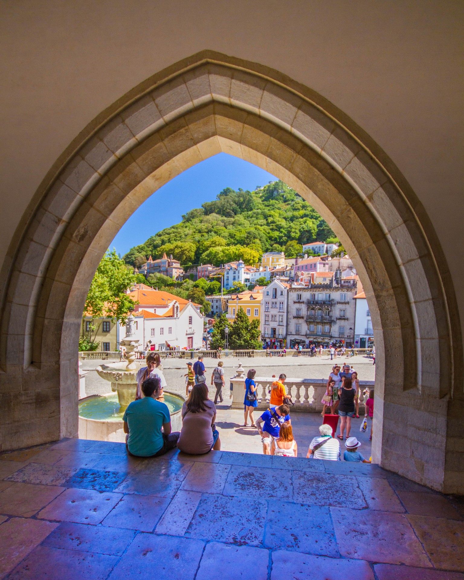 Tourists walking through an historic city viewed through a peaked archway - Sintra, Portugal