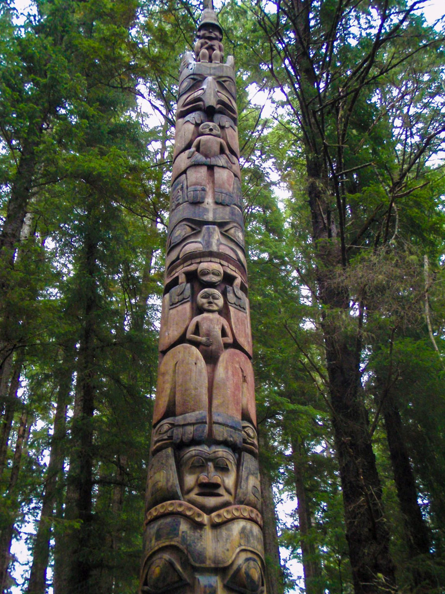 A lone totem pole amidst tress in Sitka's National Historical Park.