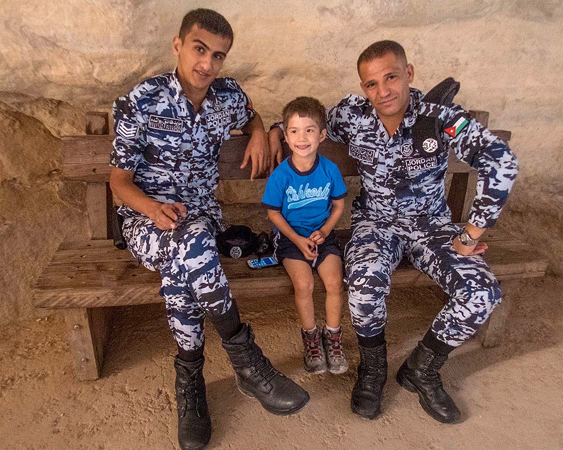 Boy poses with two Jordanian Police officers