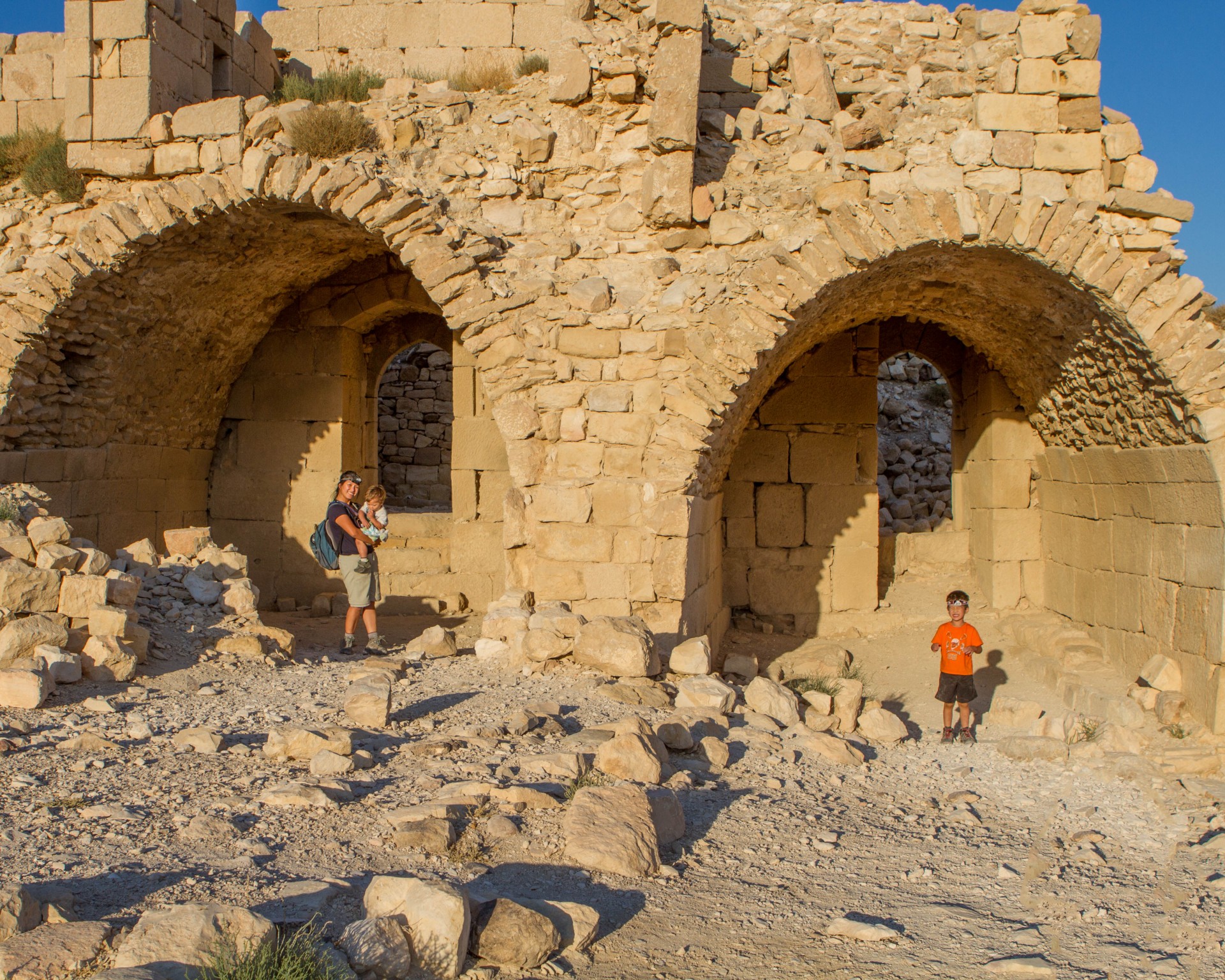Young boy and a Mother and toddler pose in arches in a desert castle