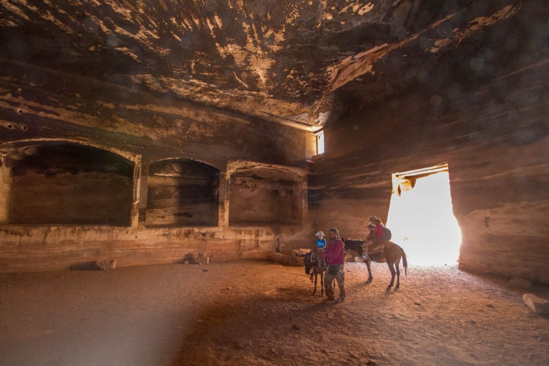 Family explores caves on horseback in Petra