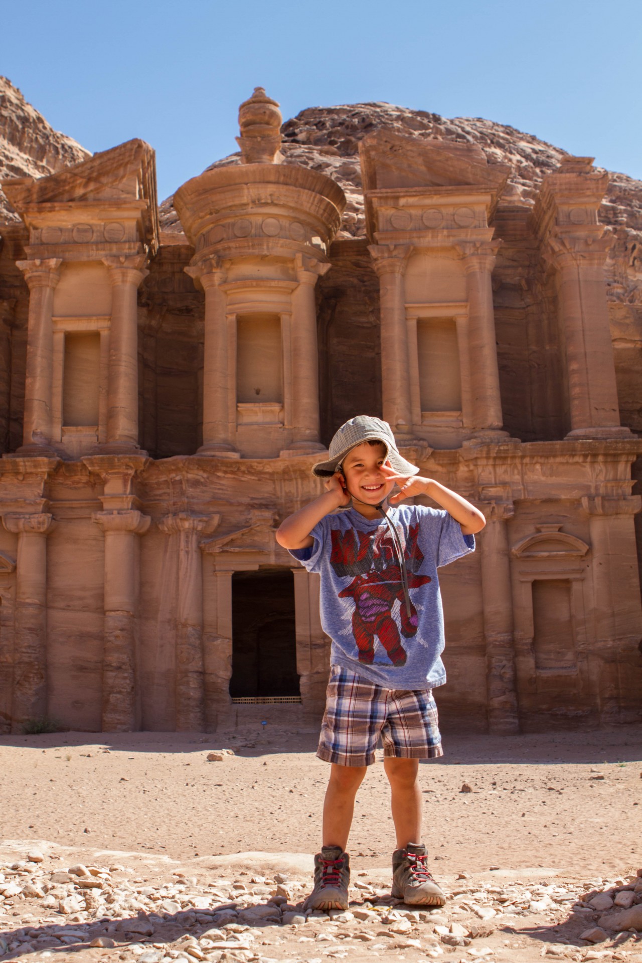 Young boy smiles in front of the Monastery in Petra