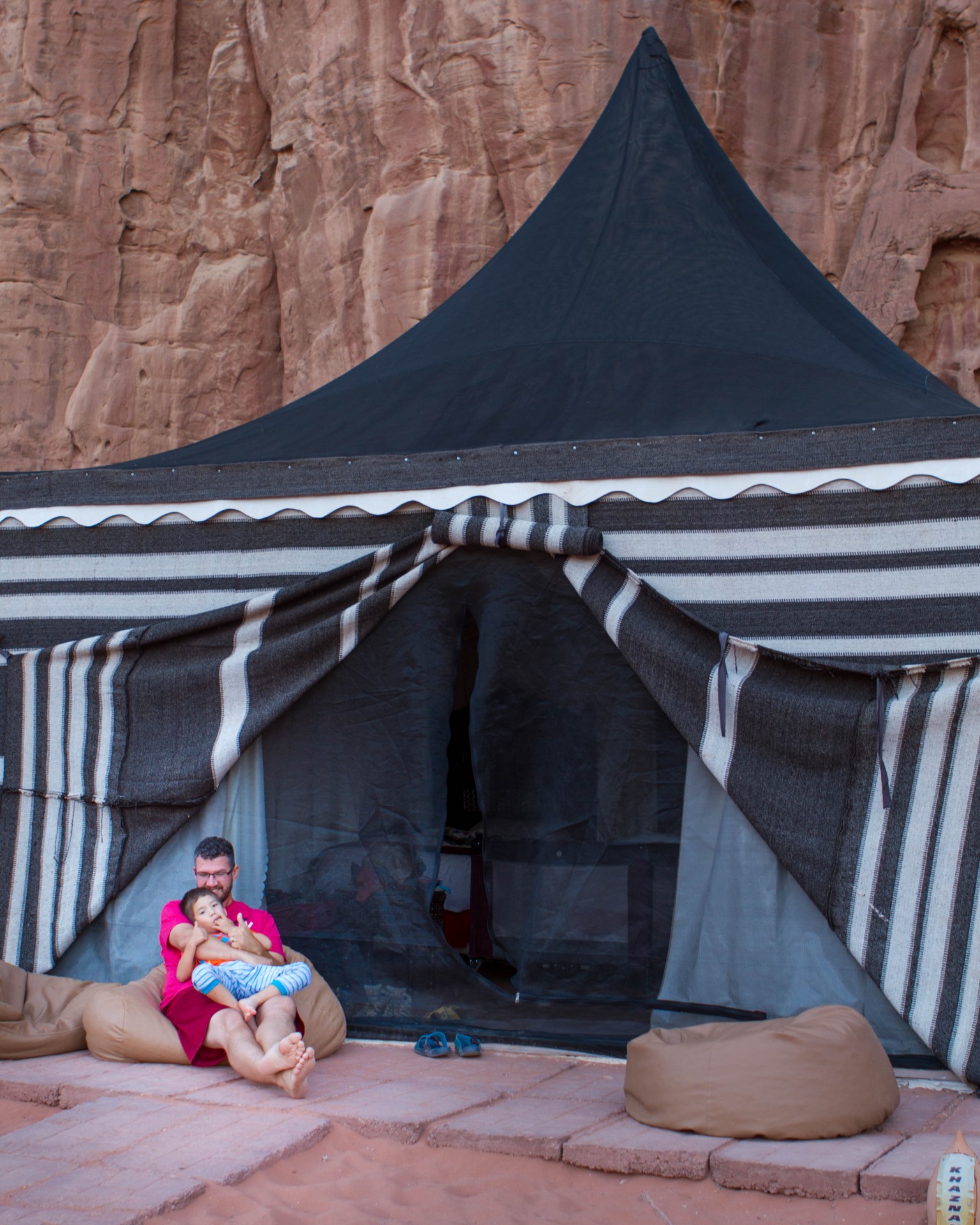 Father and son snuggle in front of a Bedouin camp in Wadi Rum Jordan