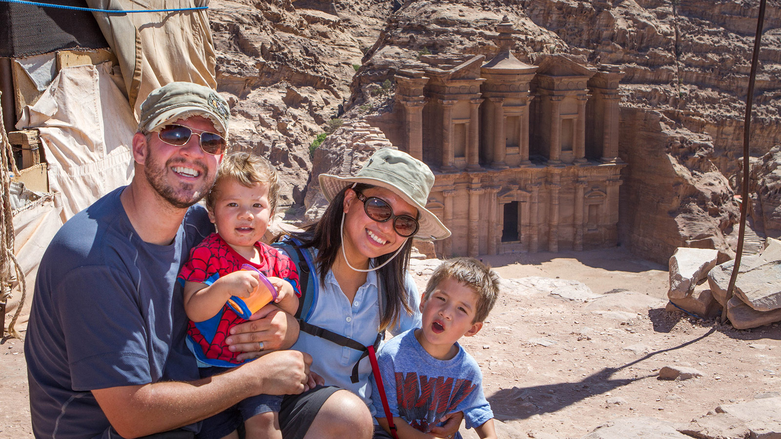 Family smiles in front of the Monastery in Petra