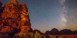 The milky way lines the sky and is framed by mountains in Wadi Rum desert in Jordan