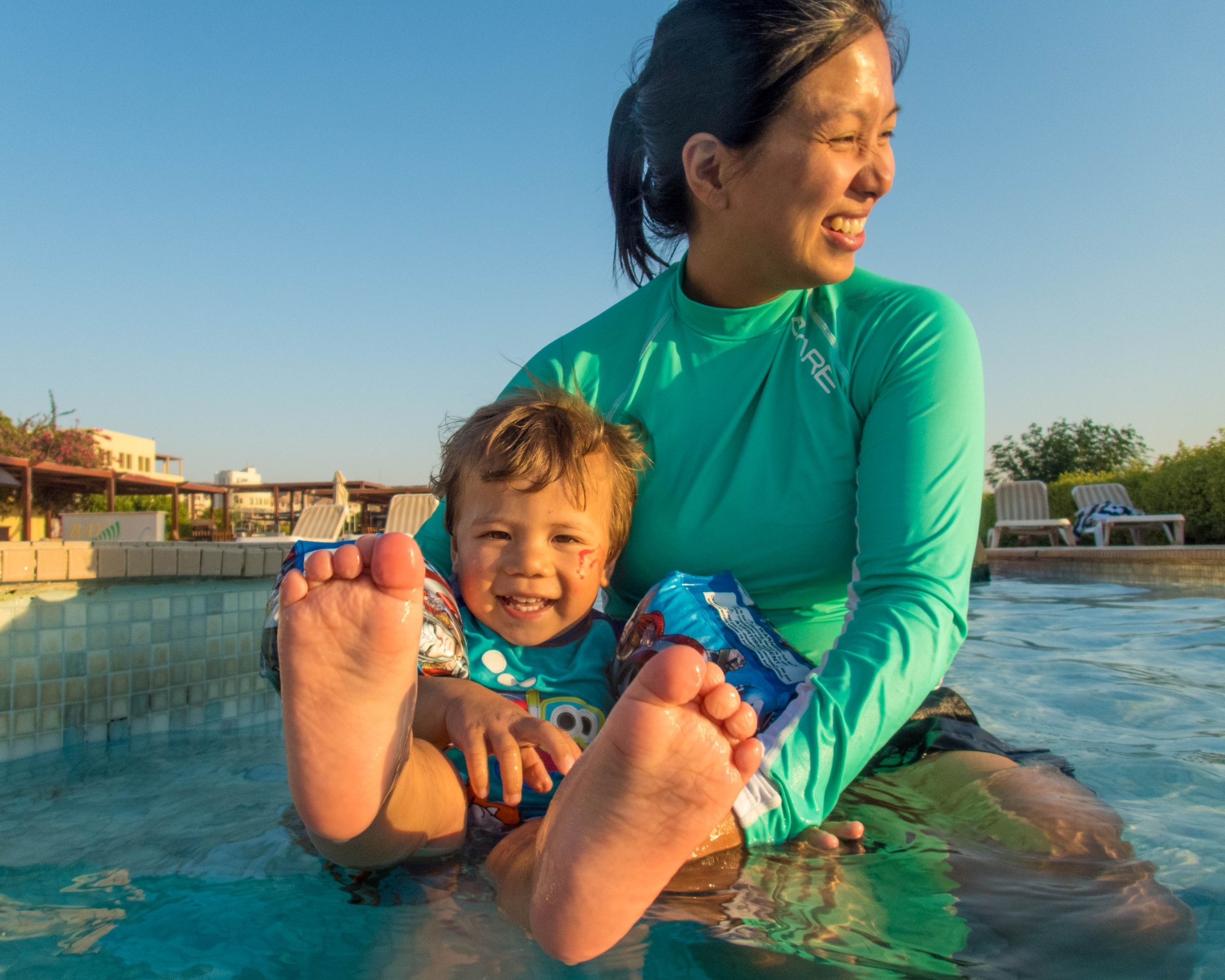 Mother and son splashing in a pool at the Radisson Blu Resort near the Red Sea, Jordan.