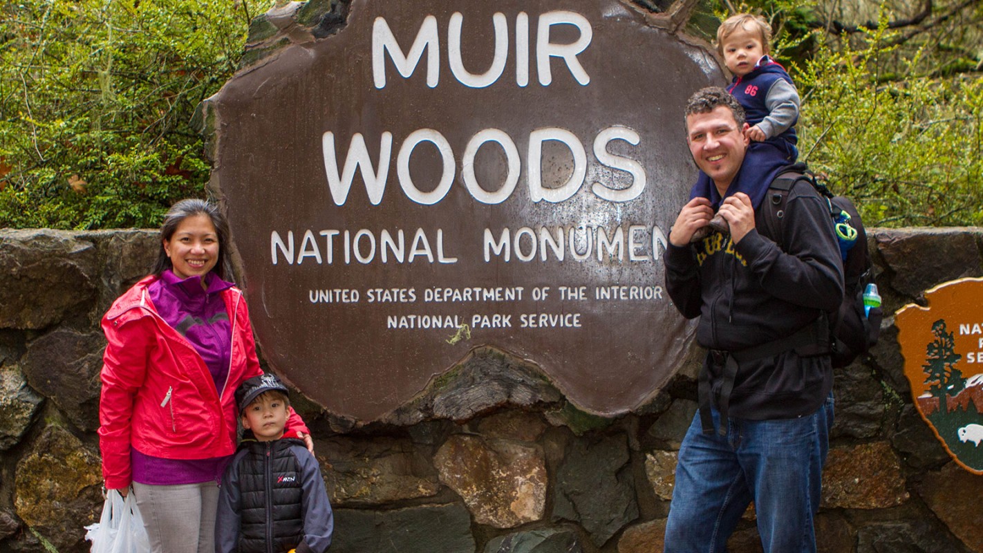 Family in front of sign at Muir Woods National Monument