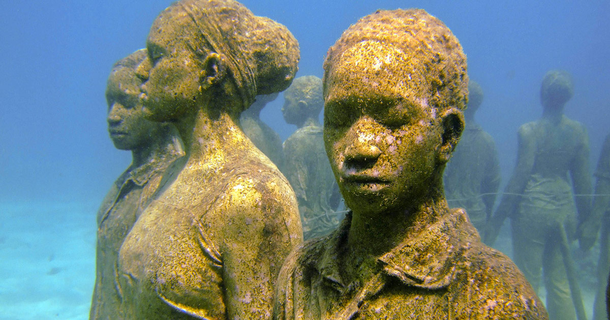 Statues of children holding hands in a circle beneath the ocean