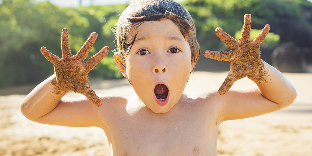 Young boy at the beach with his mouth and eyes wide