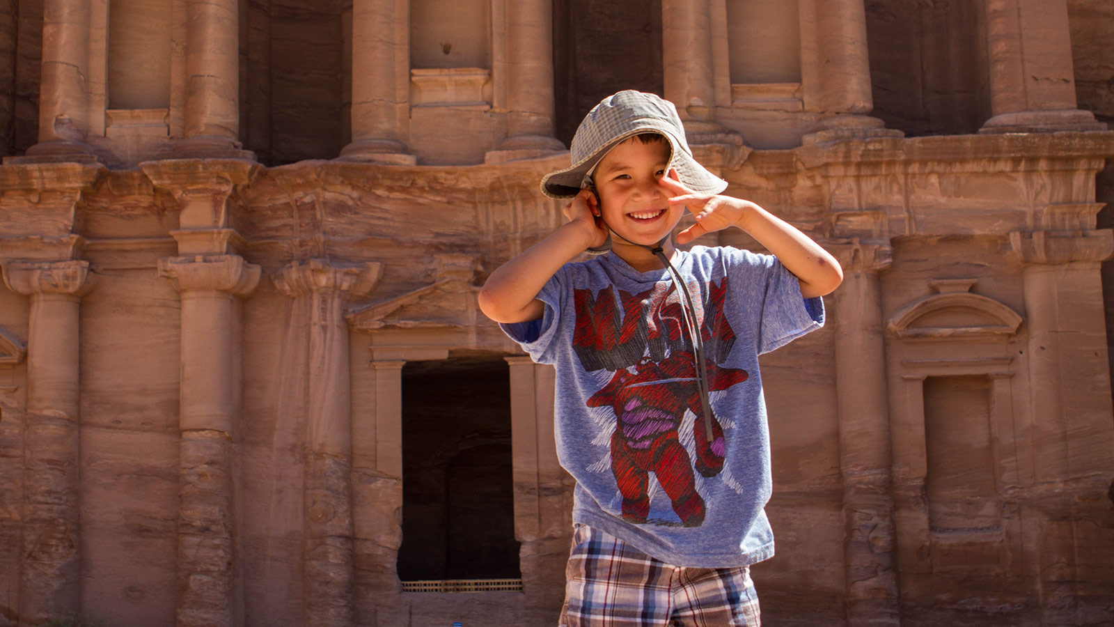 Amazing Experiences for Children in Jordan child standing in front of the Petra Monastery