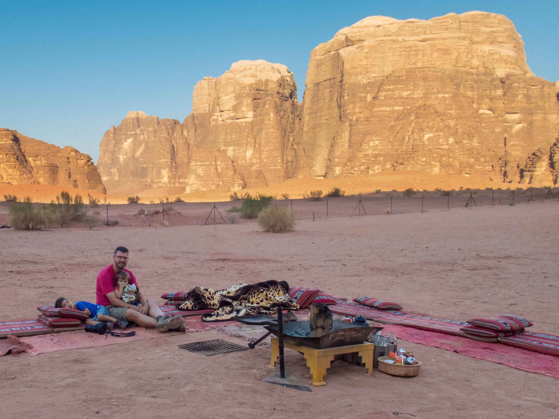 Father and son sit by a campfire in Wadi Rum
