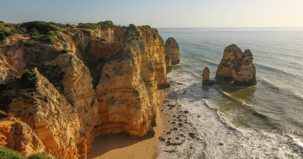 Sunlit cliffs and a beach in Portugal's Algarve