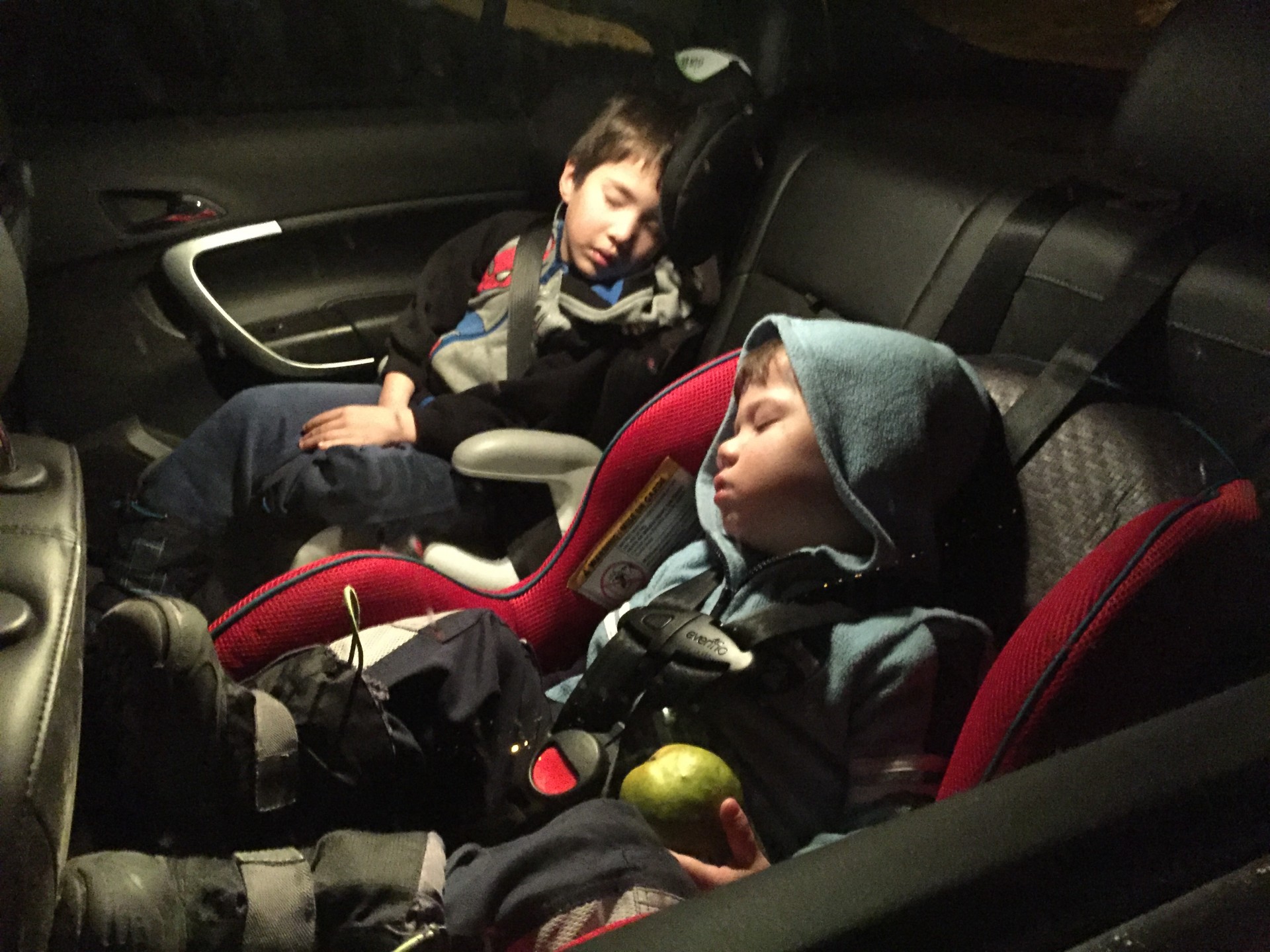 Two children sleep in a carseat - helping kids find nap time on the road