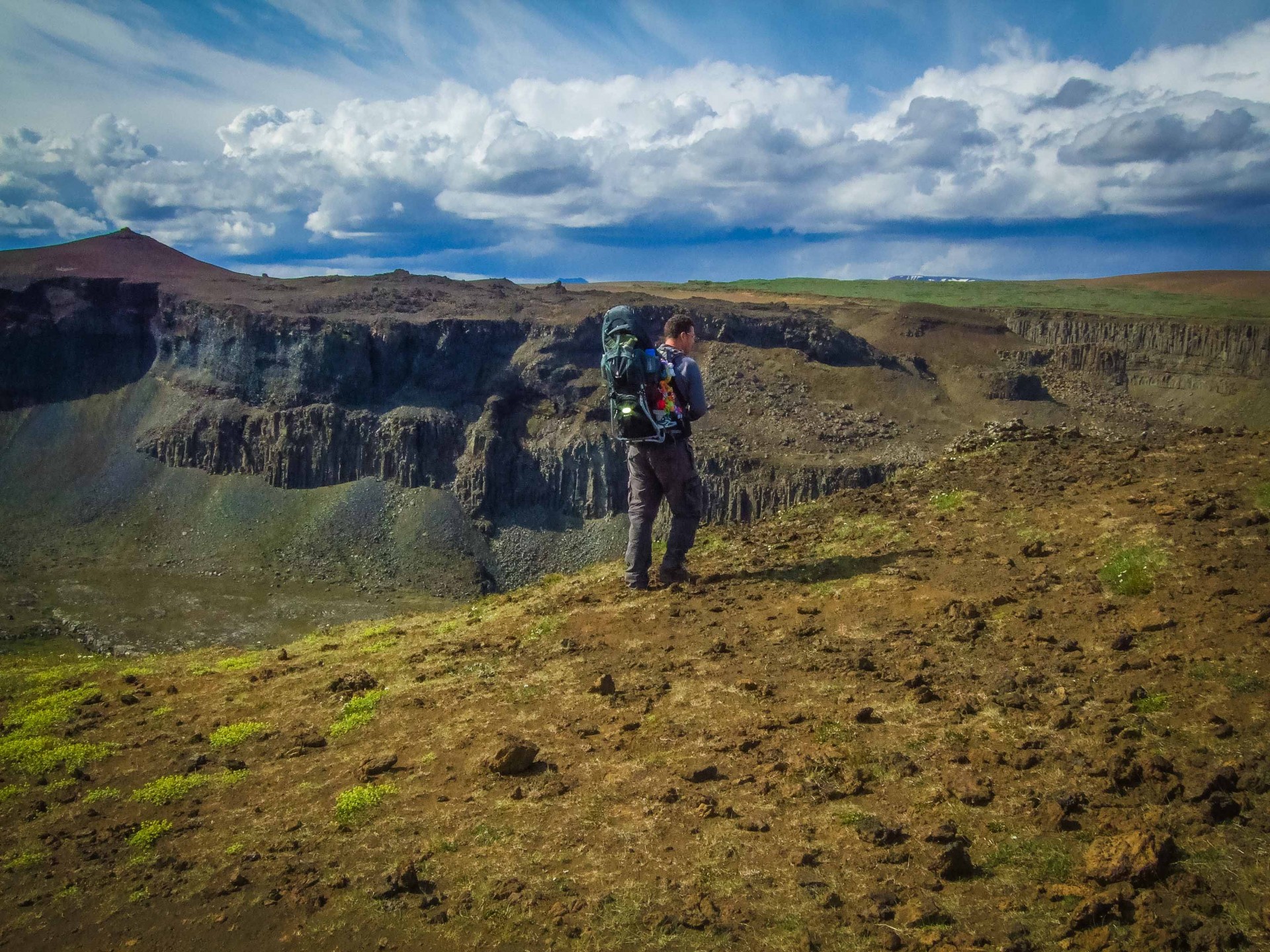 Man carrying child carrier along a steep ridge - Deuter Kid Comfort III