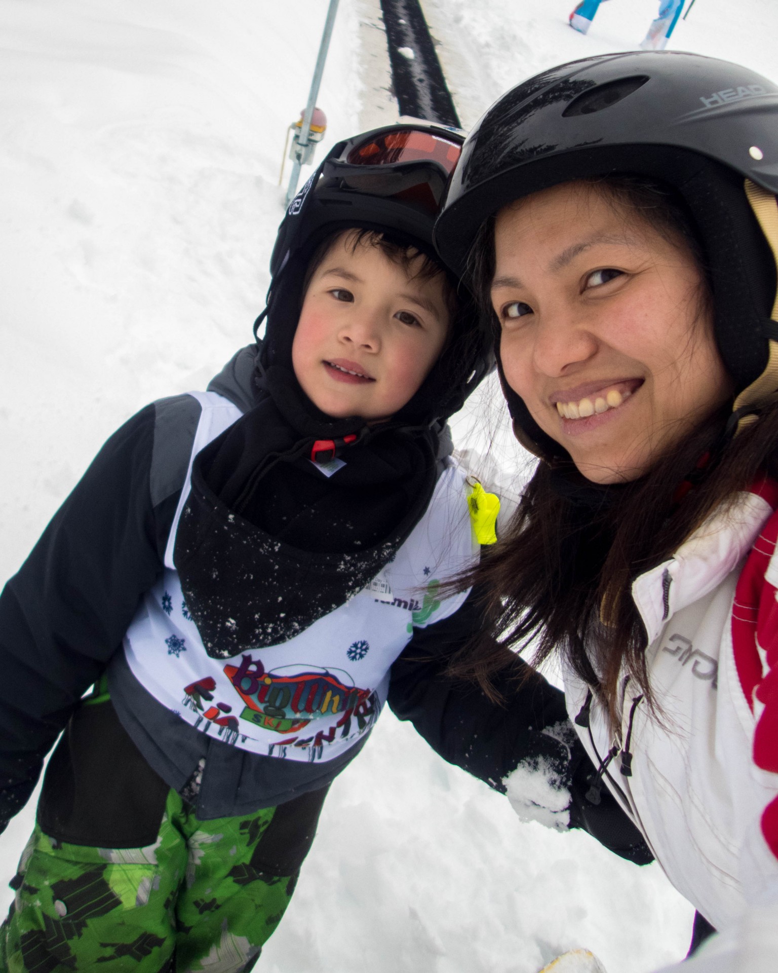 Mom and son in ski outfits smile for the camera - C gets his report card from his instructor at Big White