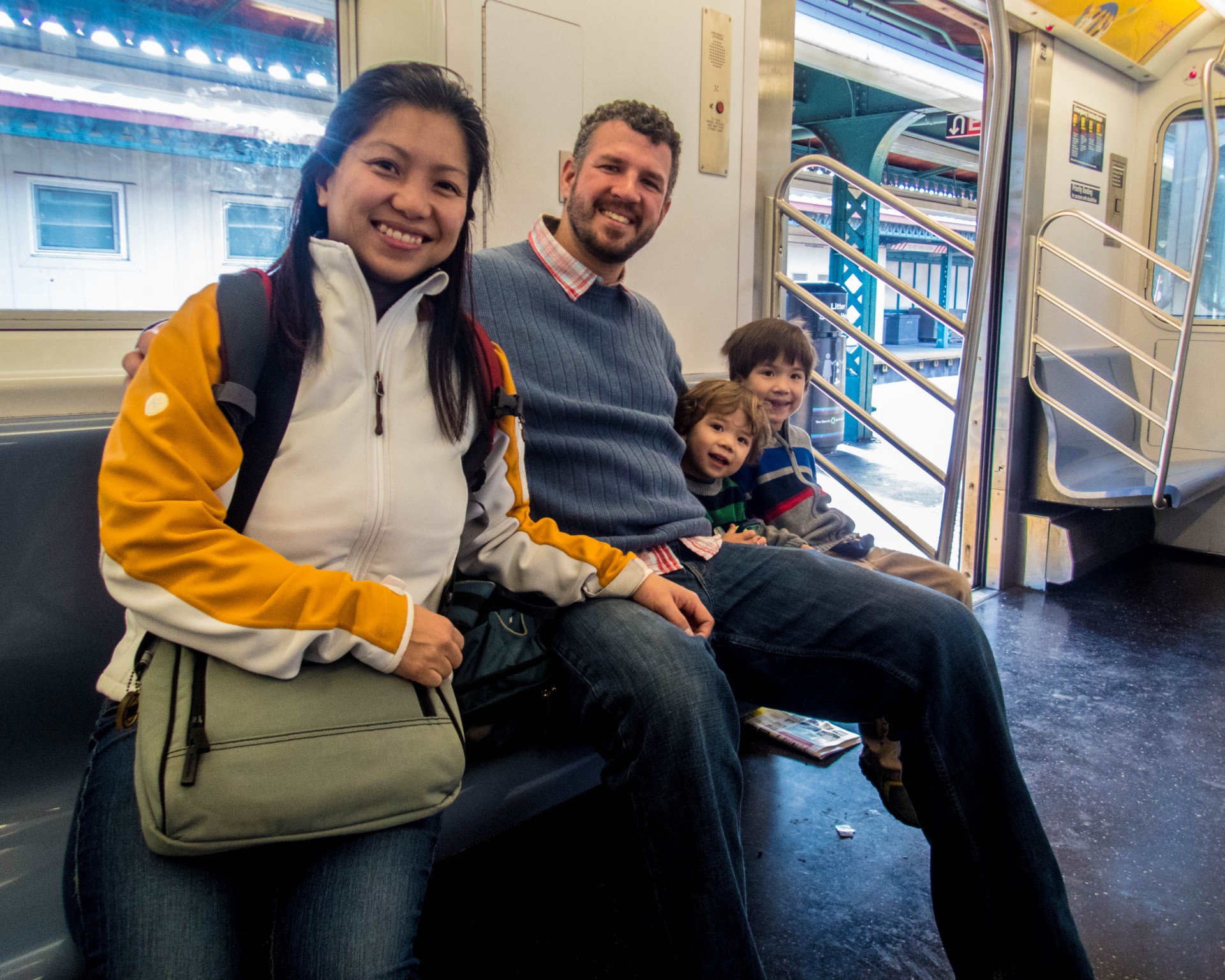 family smiling on a subway - New York
