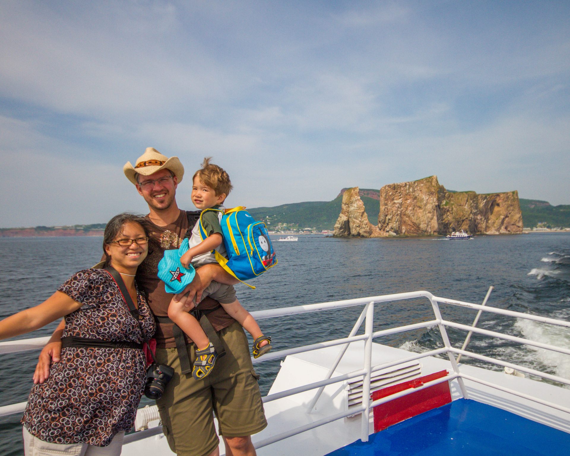 Family poses on a boat cruise of the A must do in the Gaspé Peninsula: Bonaventure Island and Percé Rock.