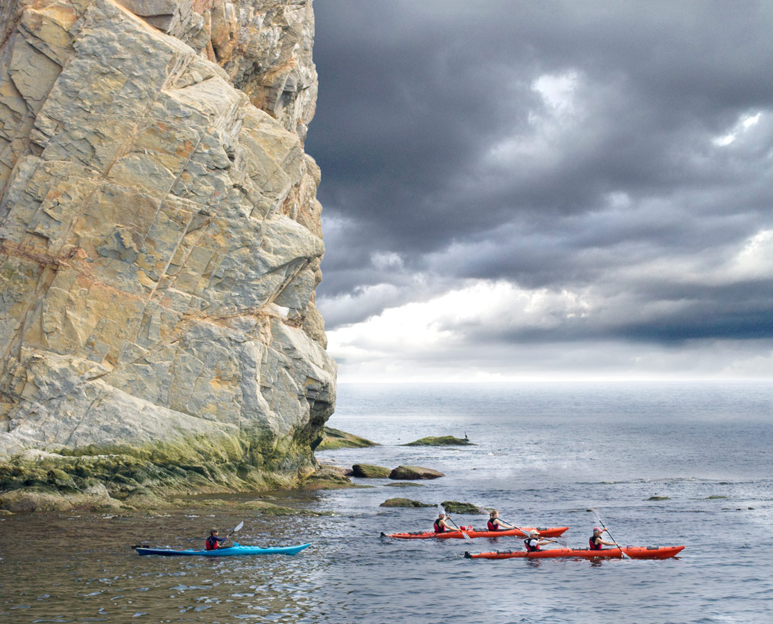 Kayakers explore the area around Perce Rock near Bonaventure Island on the Gaspe Peninsula of Quebec