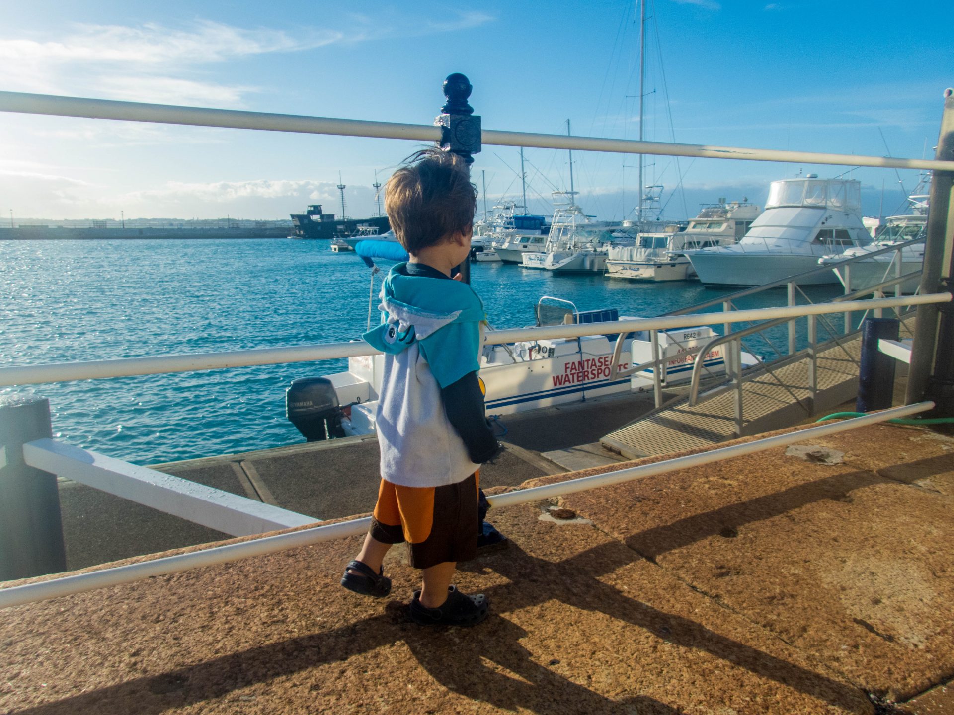Toddler wearing swim gear walks along a boat pier - Boating in Bermuda