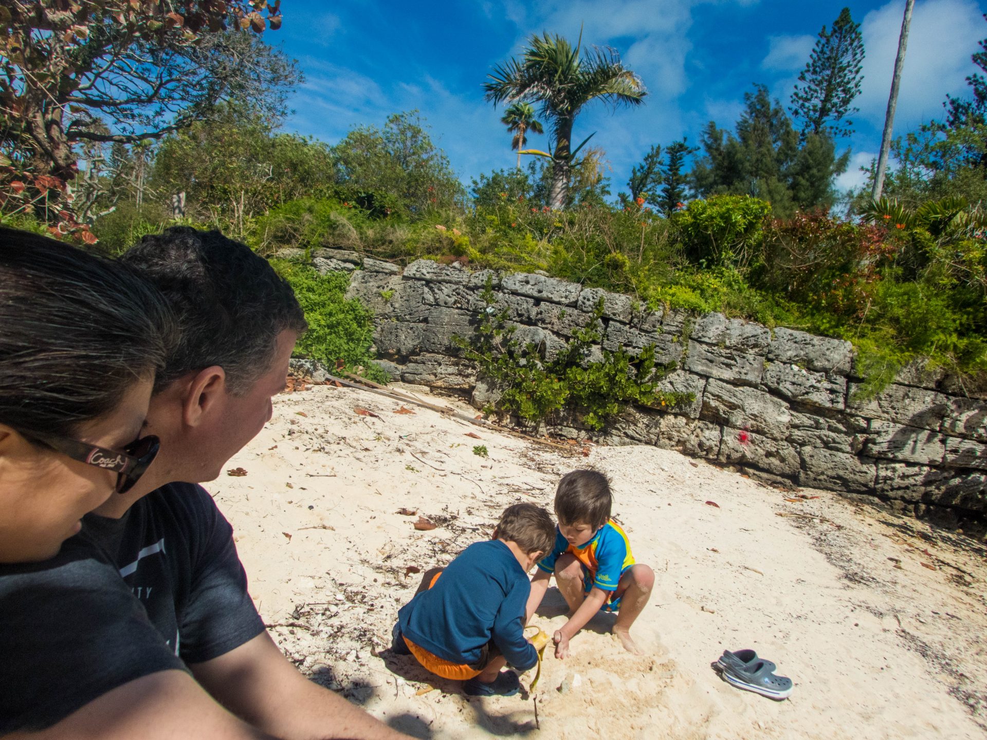 Two parents watch their children playing in the sand on the beach - Boating in Bermuda
