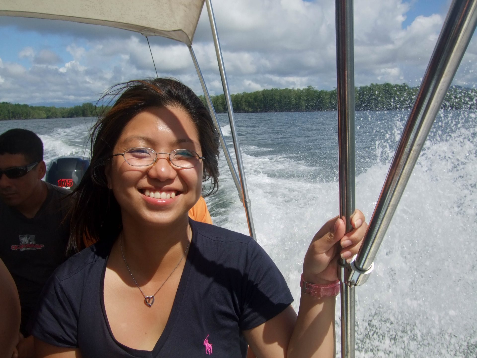 A young woman smiles while riding a motor-boat in the Caribbean