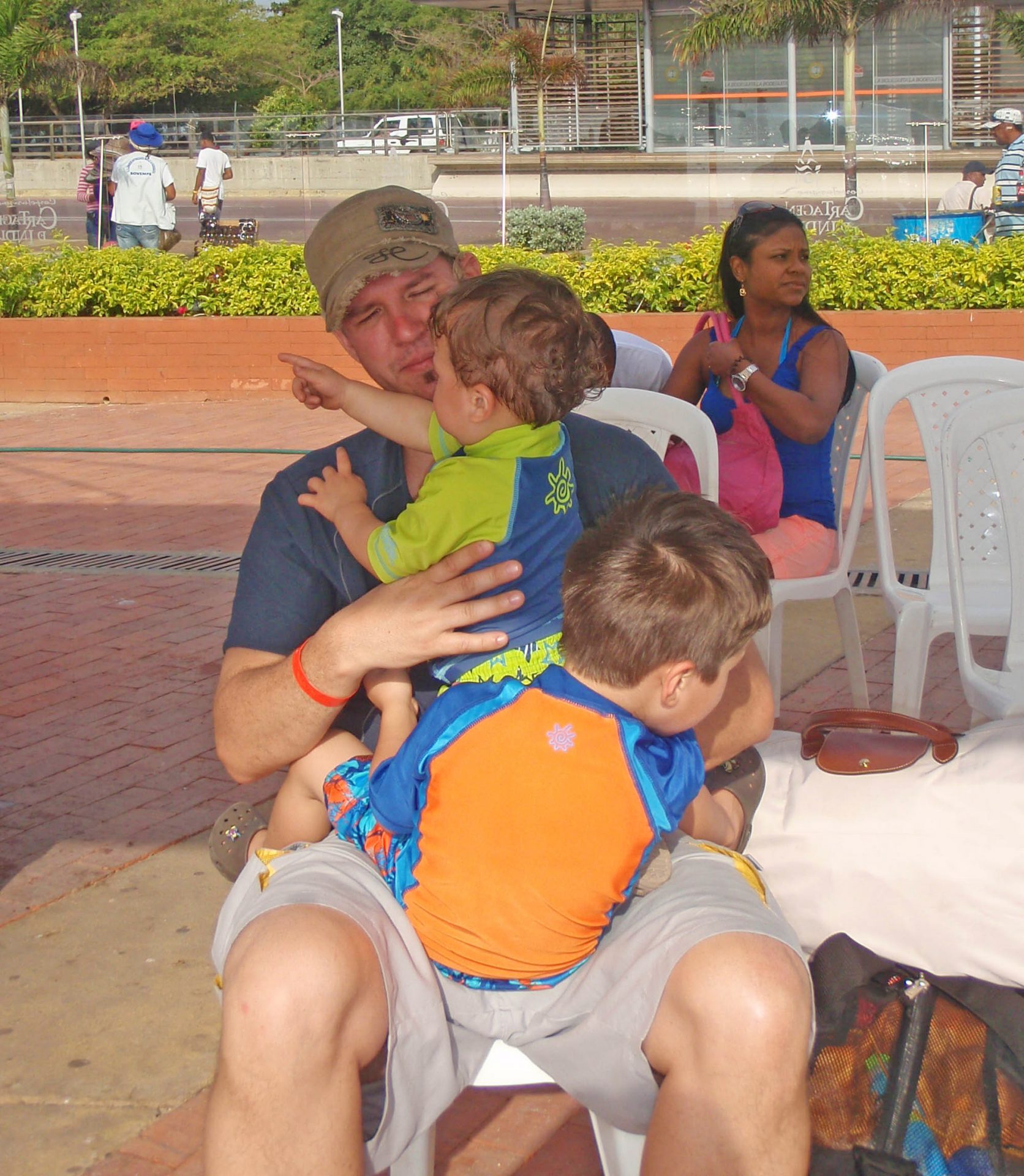 Father with two boys on his lap waiting at the pier for their boat to Pirate Island.