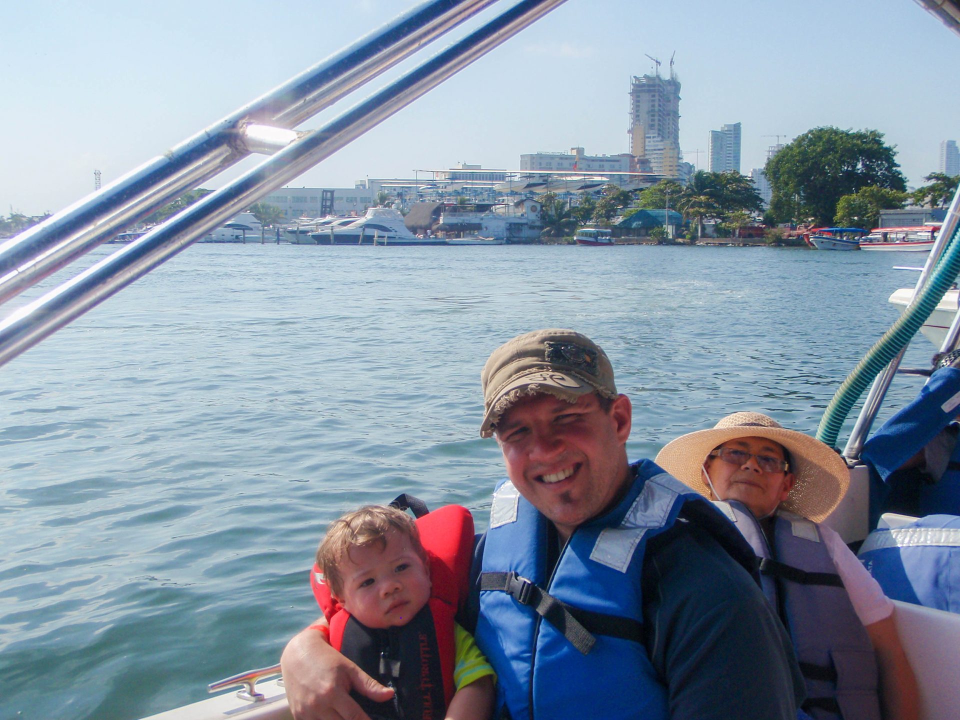 Father holds son on his lap on boat to Pirate Island.