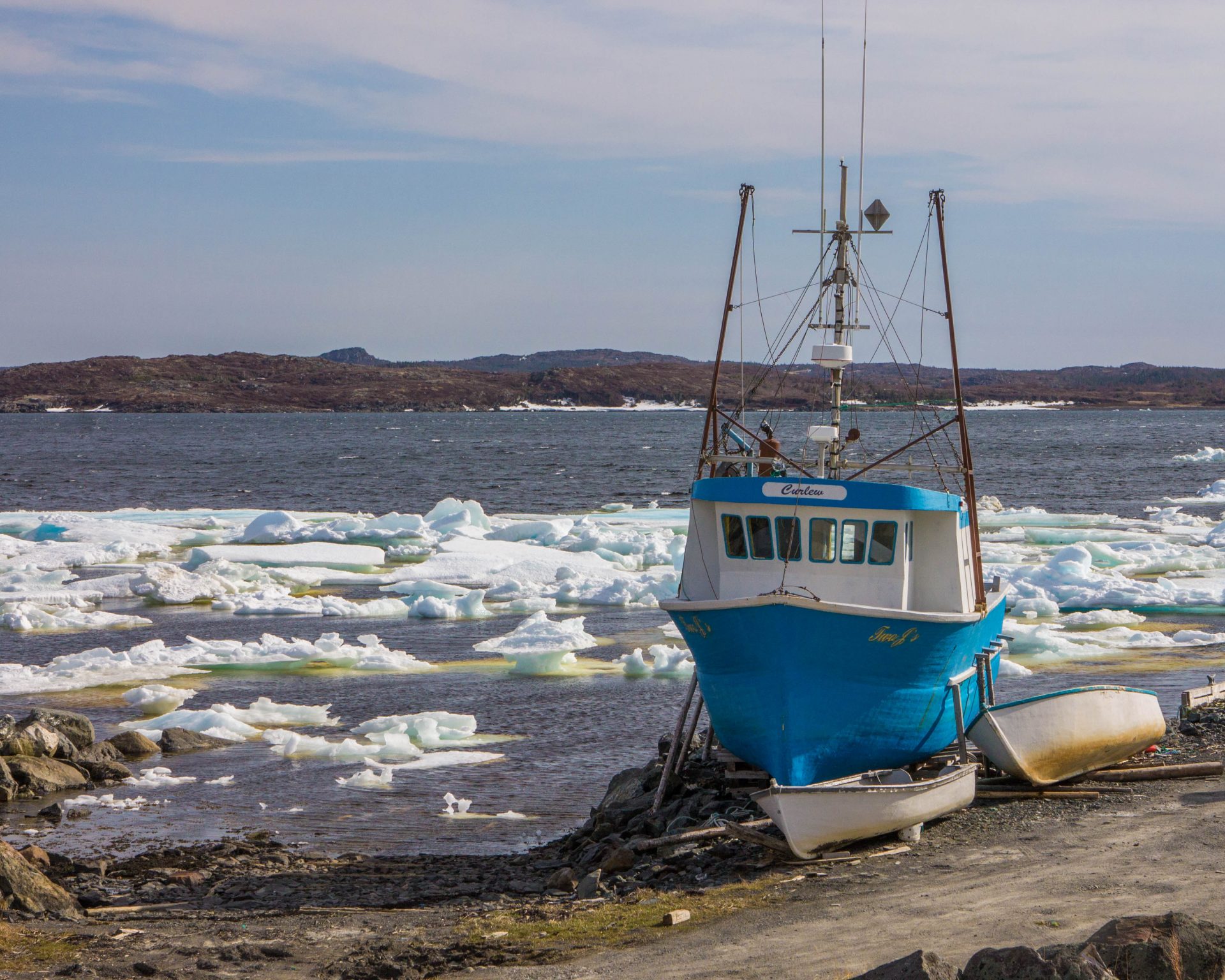 Fishing Boat docked amidst ice floes in the bay.