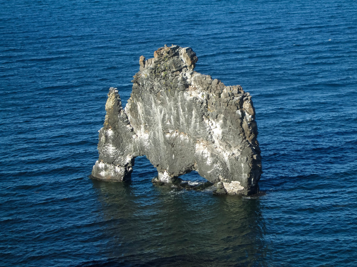 A large, thin rock with two arches sits in the water off Icelands Vatnsnes-peninsula - An Epic 14 Day Iceland Itinerary