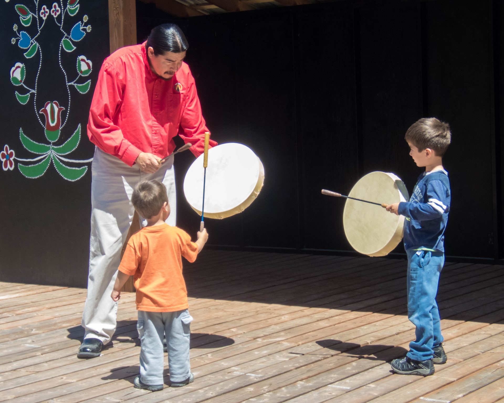 Elder teaches boys some of the intricacies of drumming as part of the Great Spirit Trail Voice of the Drum Make and Take Experience on Manitoulin Island.