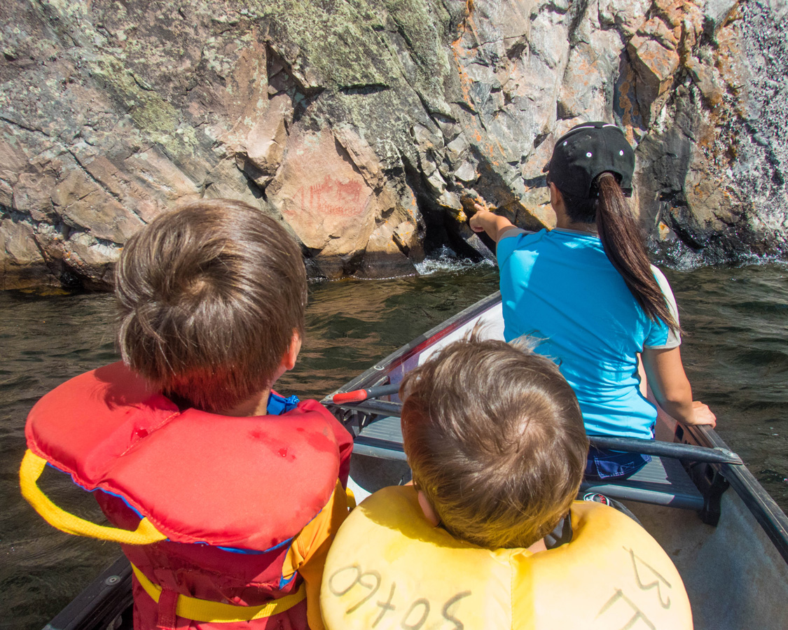 A mother points to a native pictograph from a canoe - Top things to do in Bon Echo Provincial Park