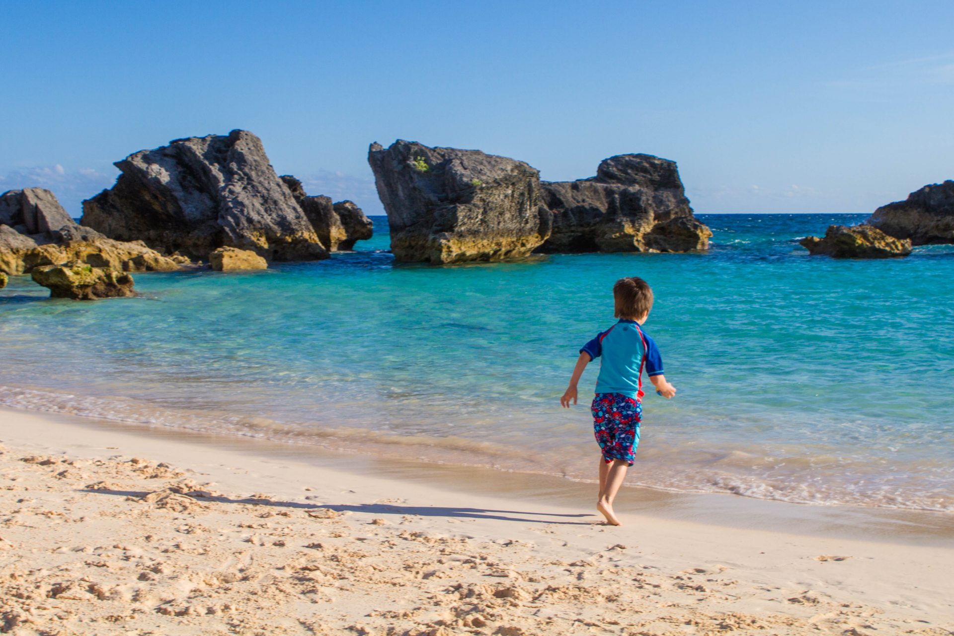 Boy running towards East Whale Beach on our search for the best Bermuda beach.