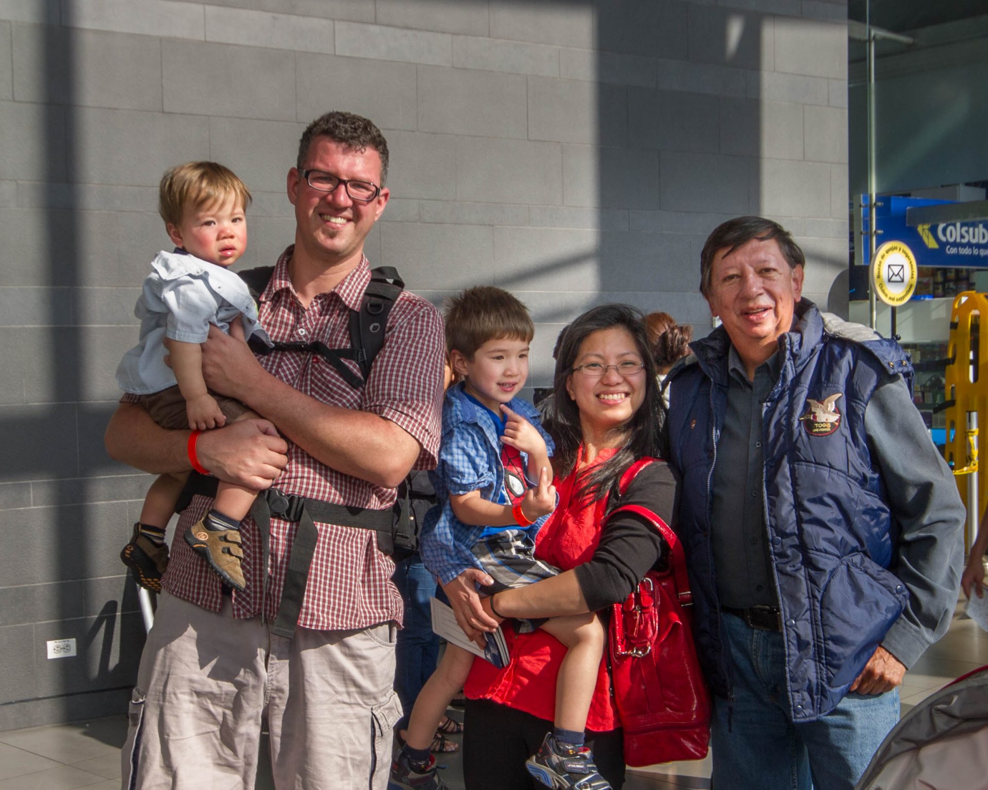 Men, woman and children pose in the Bogota airport.