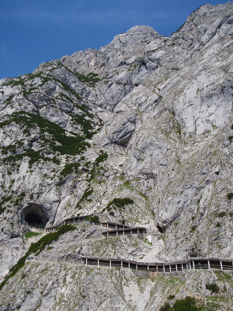 A narrow trail winds up a mountain towards a cave entrance - caves you can visit with kids