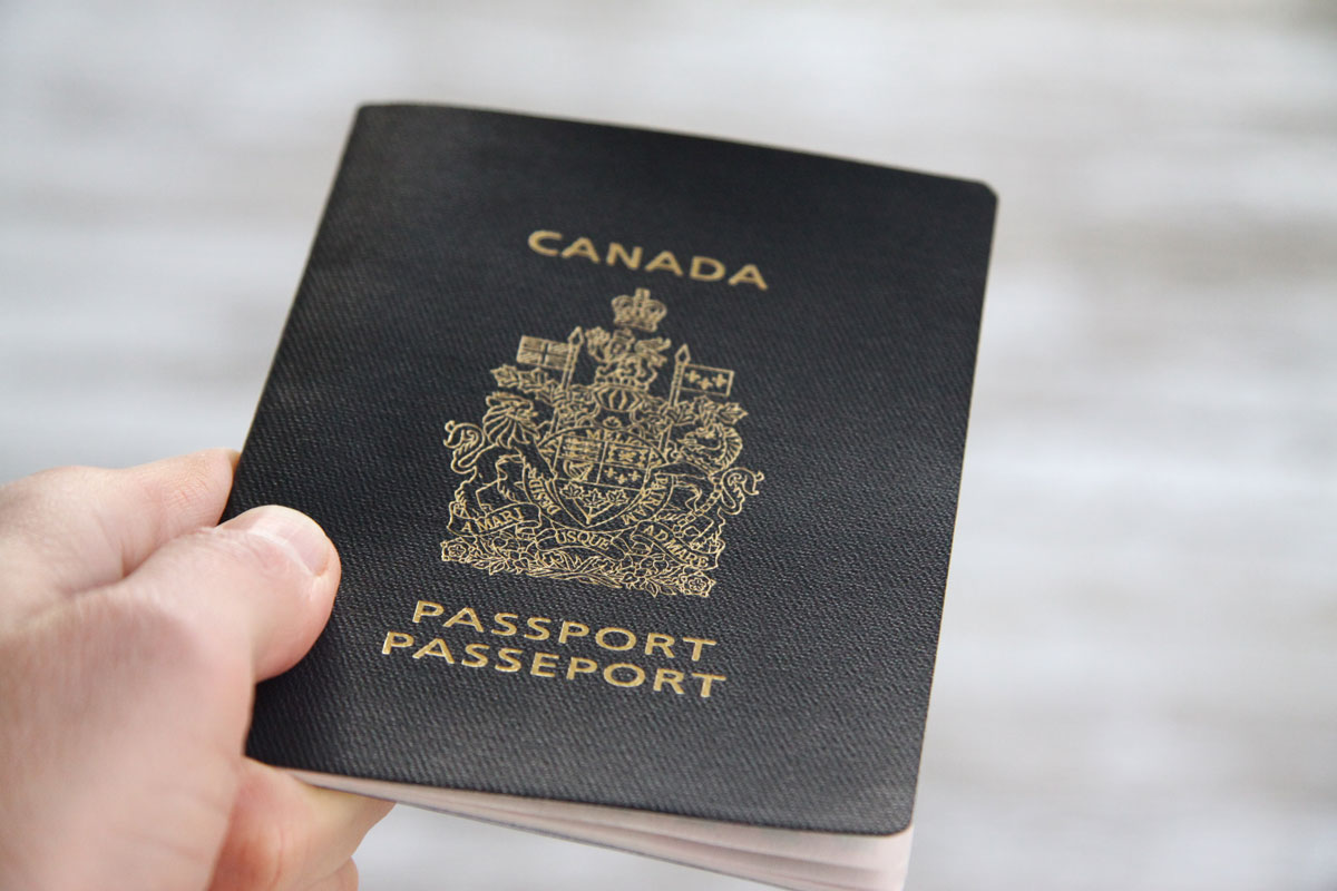 A closeup of a hand holding a Canadian passport - plan international family vacations