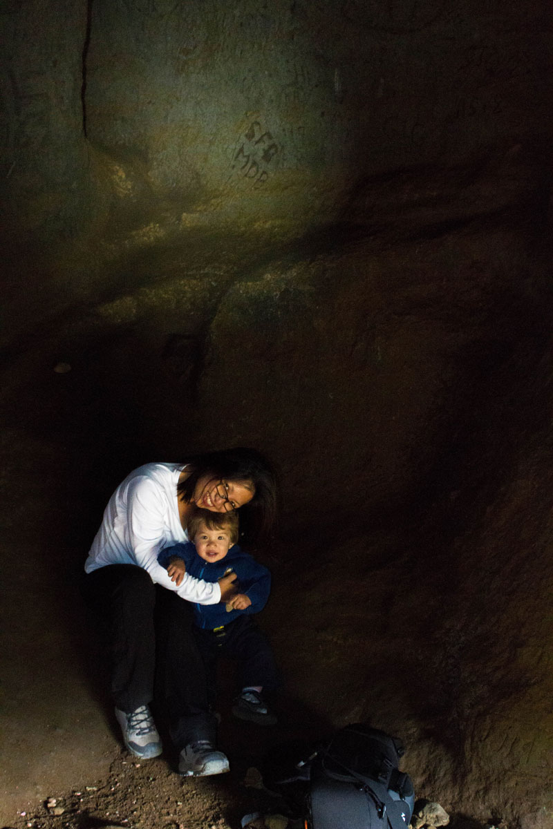 A mother snuggles her young son in Songhellir cave in Iceland - CAves you can visit with kids