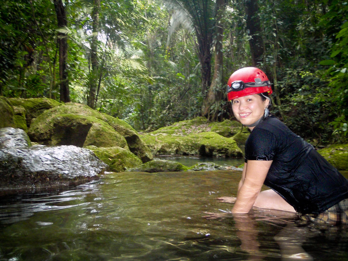 Women getting ready to cross a stream as part of the caving experience at ATM one of the must do activities in Belize.