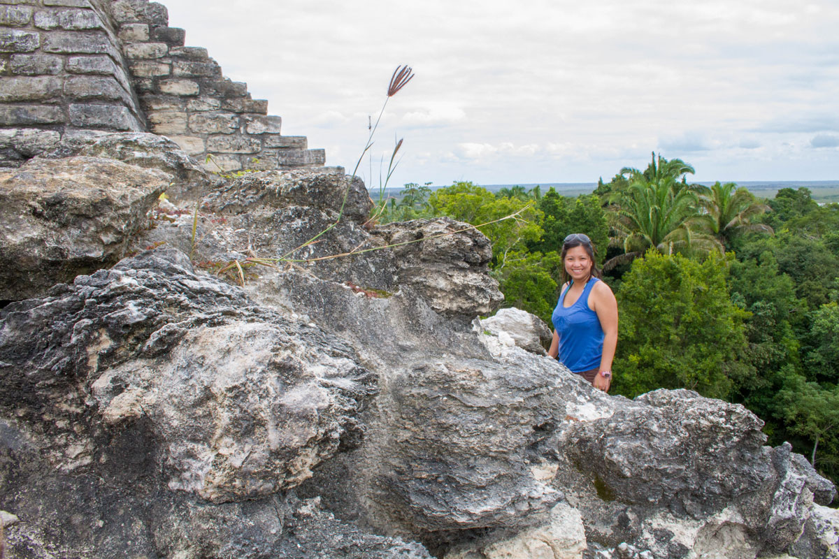 Woman climbing ruins in Lamanai.