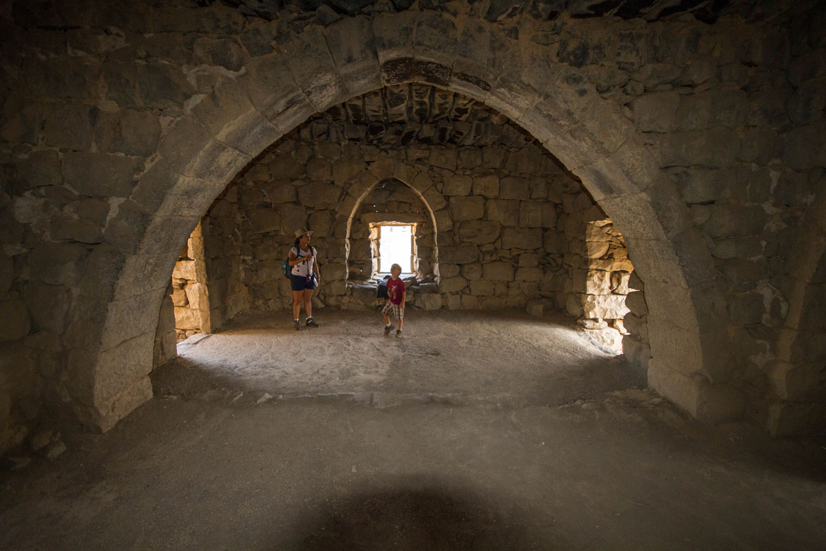 A woman and a young boy explore a room in a desert castle that once housed the famous T.E. Lawrence