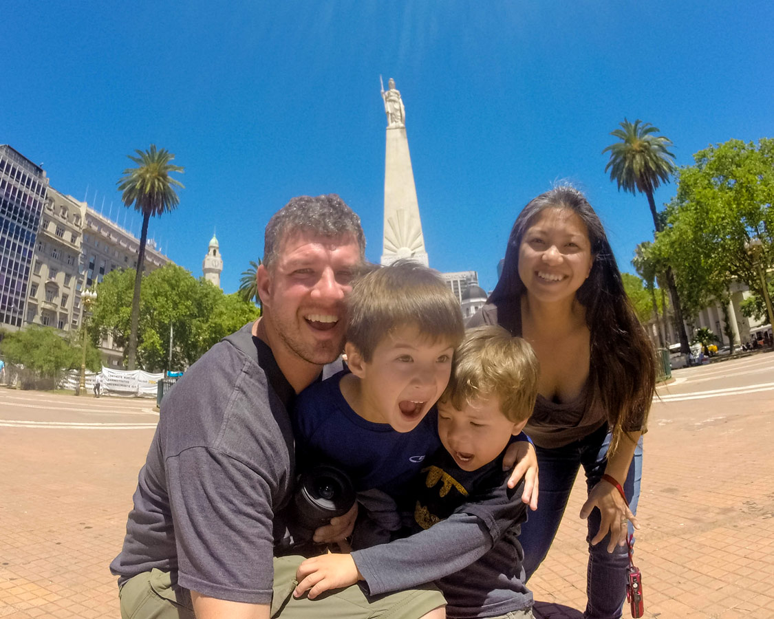 Family take a picture in front of the Pyramide de Mayo in microcentro which has many Buenos Aires highlights.