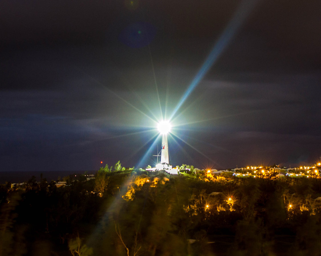 a lighthouse shines in the darkness above Horseshoe Bay Beach in Bermuda