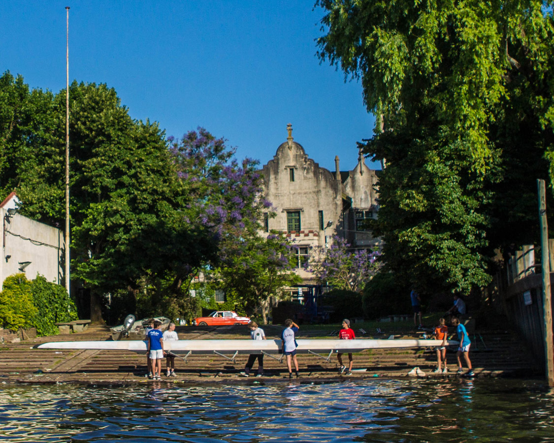 Rowers place a boat in the water outside one of the many rowing clubs in Tigre