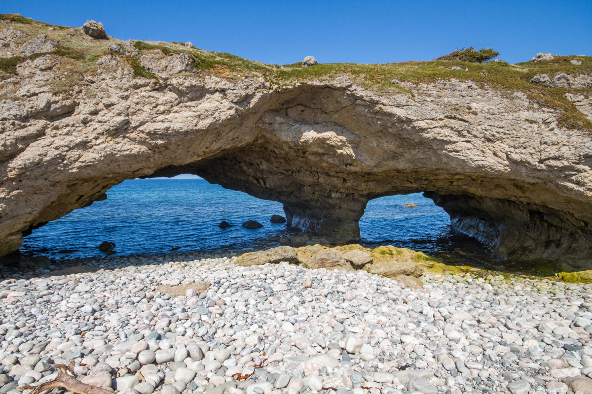 A double arch looking out onto the Atlantic Ocean at Arches Provincial Park in Newfoundland. It's one of our 12 Unforgettable Canadian Road Trips