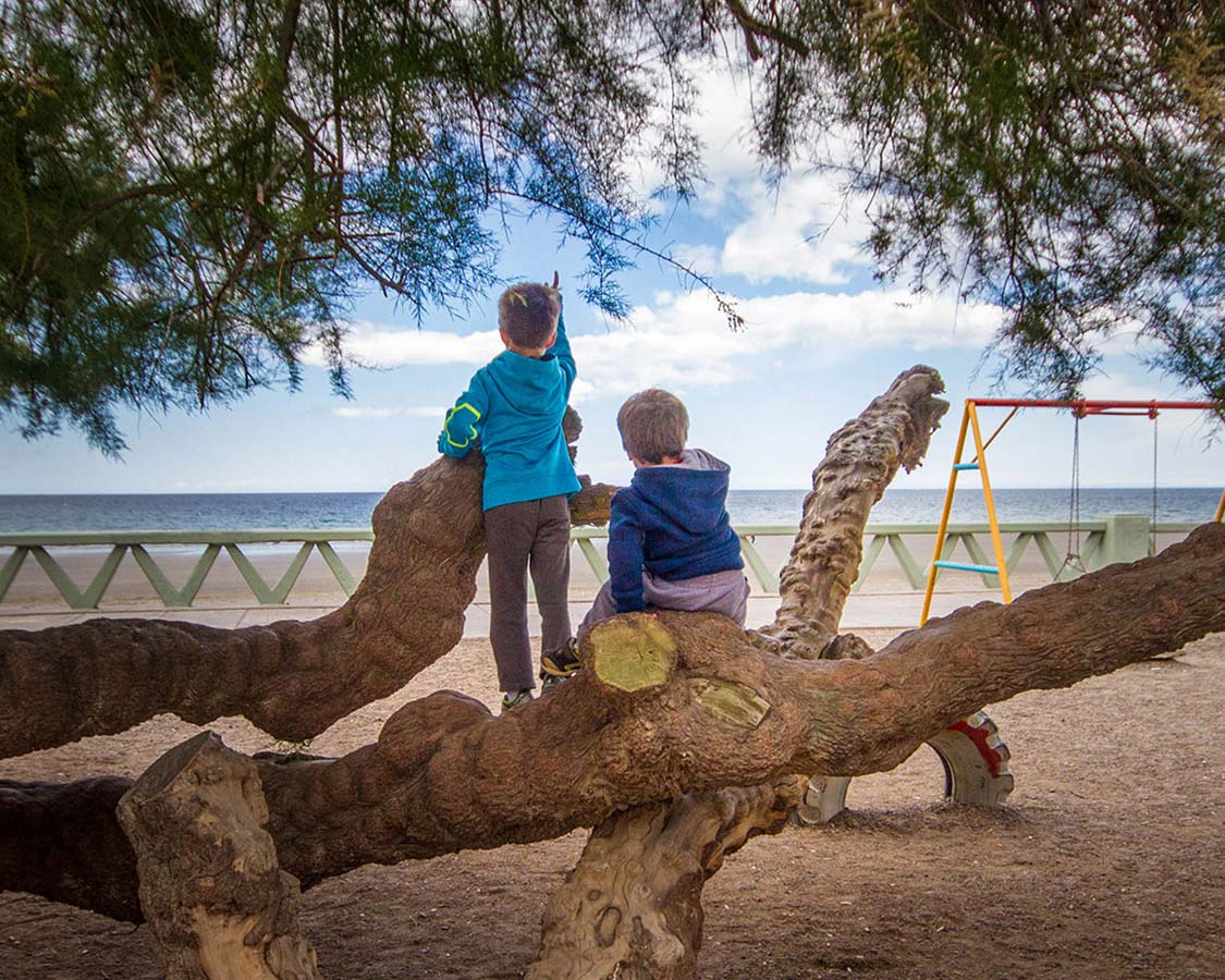 Puerto Madryn with kids playing in a playground on the beach.