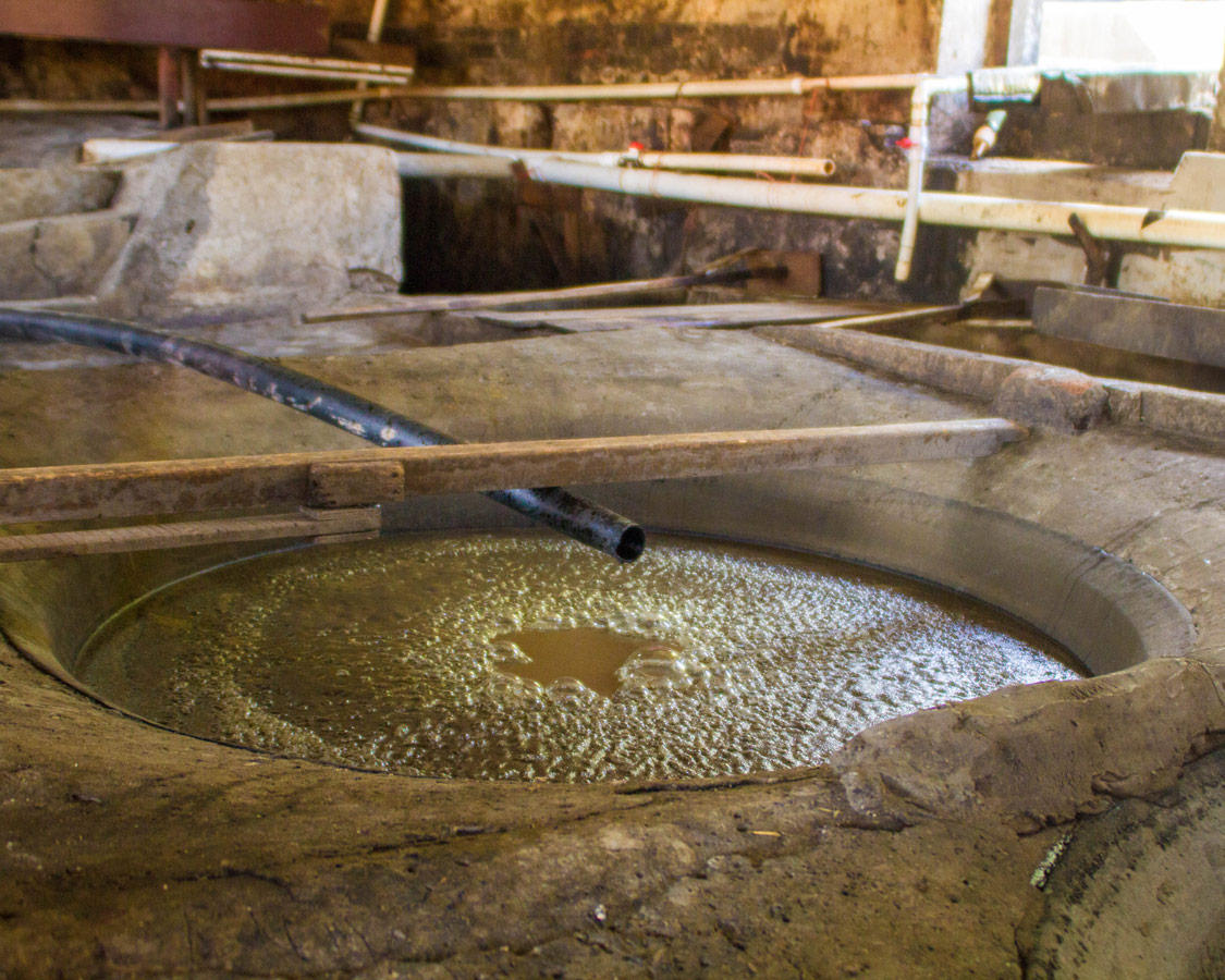 An antique copper full of brown bubbling cane juice ferments at the River Antoine Rum Distillery in Grenada