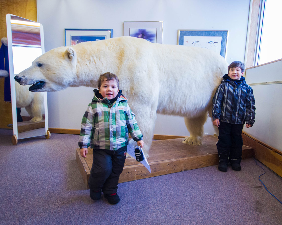 Two young boys pose beside a polar bear at the Northern Frontier Visitor's Center in Yellowknife.