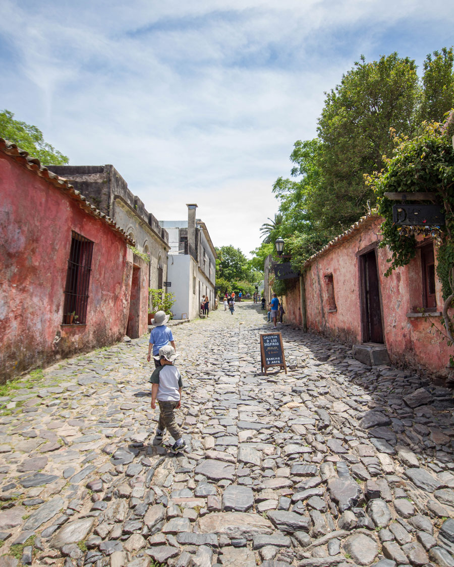 Boys walking the cobblestone street Calle de los suspiros in Colonia del Sacramento, Uruguay.