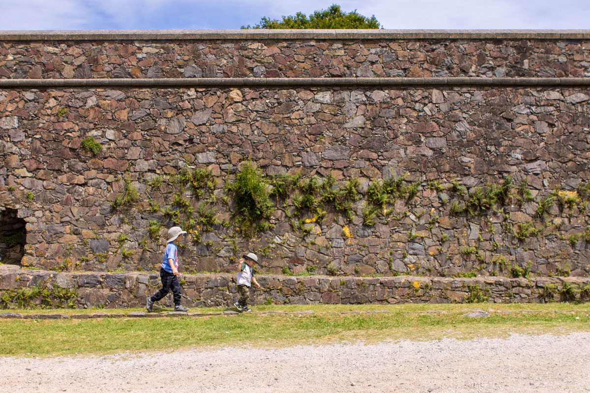 Two boys walking along the outside walls of Barrio Historico of Colonia del Sacramento.