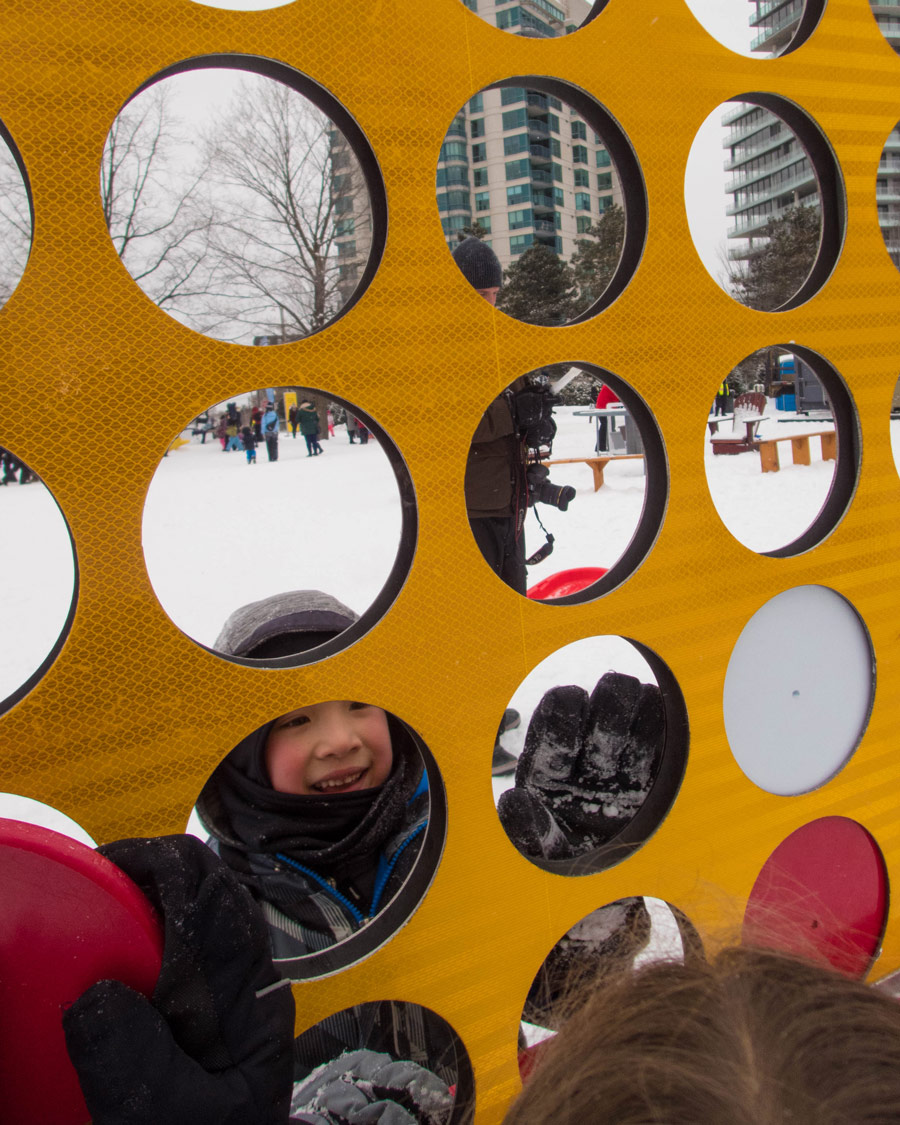 Giant Connect Four game with boy in the background.